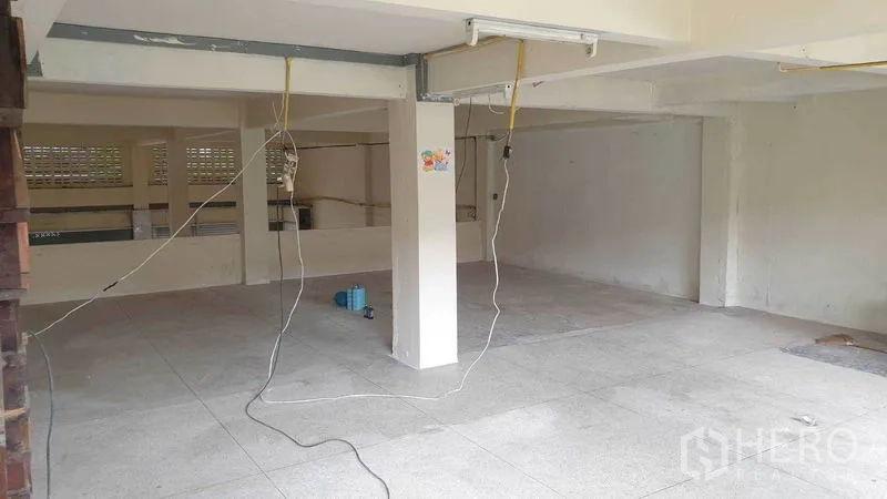 Shophouse for rent in Phra Khanong, Bangkok - Mezzanine-level workspace with tiled floor and exposed wiring.