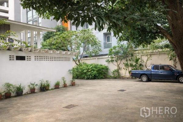 พื้นที่ขายปลีก for rent in Watthana, Bangkok - ลานจอดรถกว้างใต้ร่มไม้ พร้อมกำแพงรอบพื้นที่ ในทรัพย์สินเชิงพาณิชย์ย่านสุขุมวิท