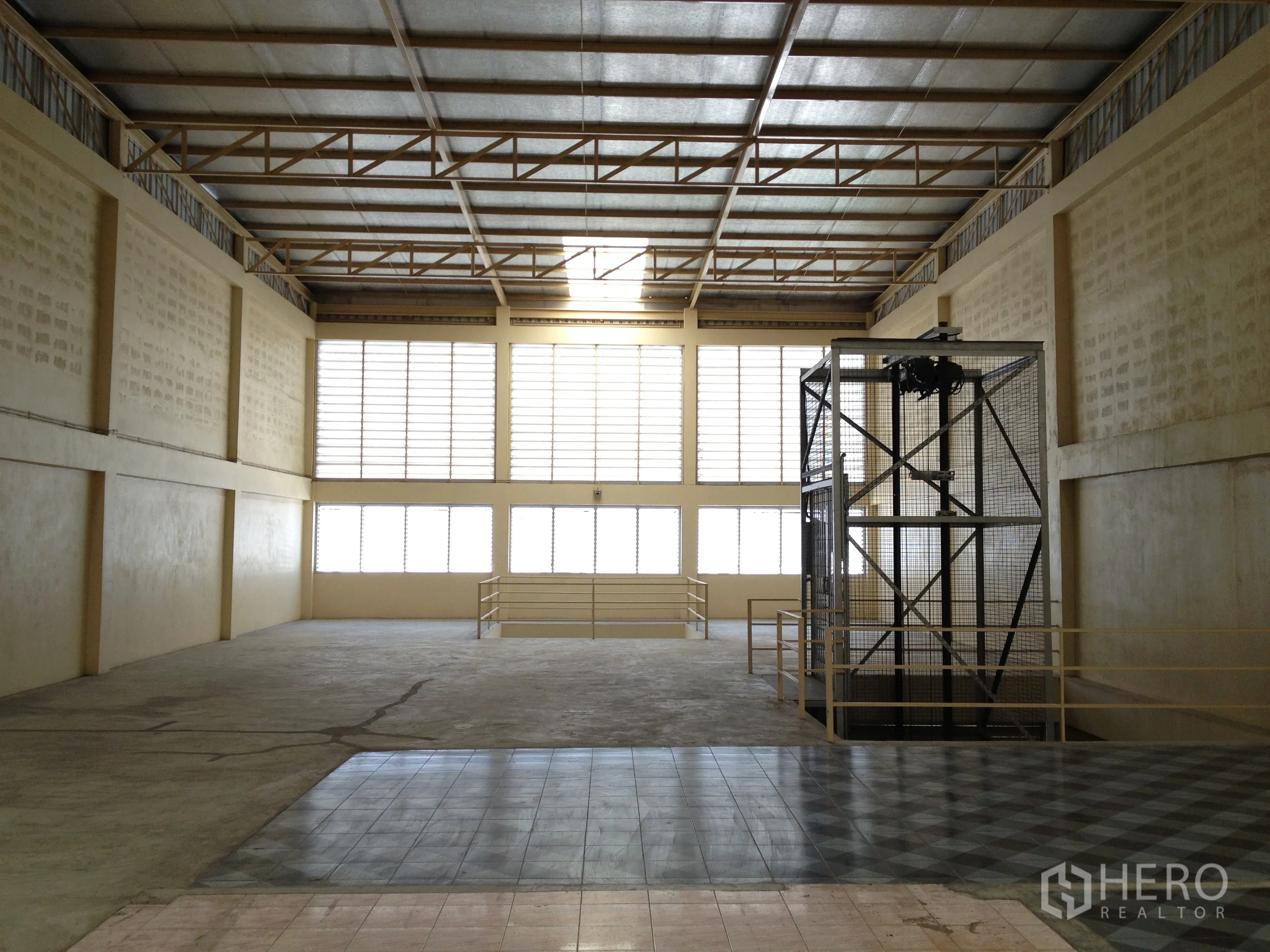 Factory for rent in Thung Khru, Bangkok - Large production floor with caged hoist well and wide window wall.