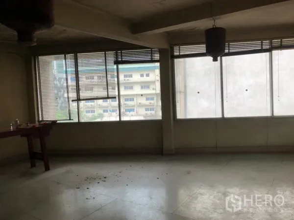 店屋 出租在Bangkok - 开放式楼层，宽幅窗户可见城市景观，地面为混凝土饰面。
