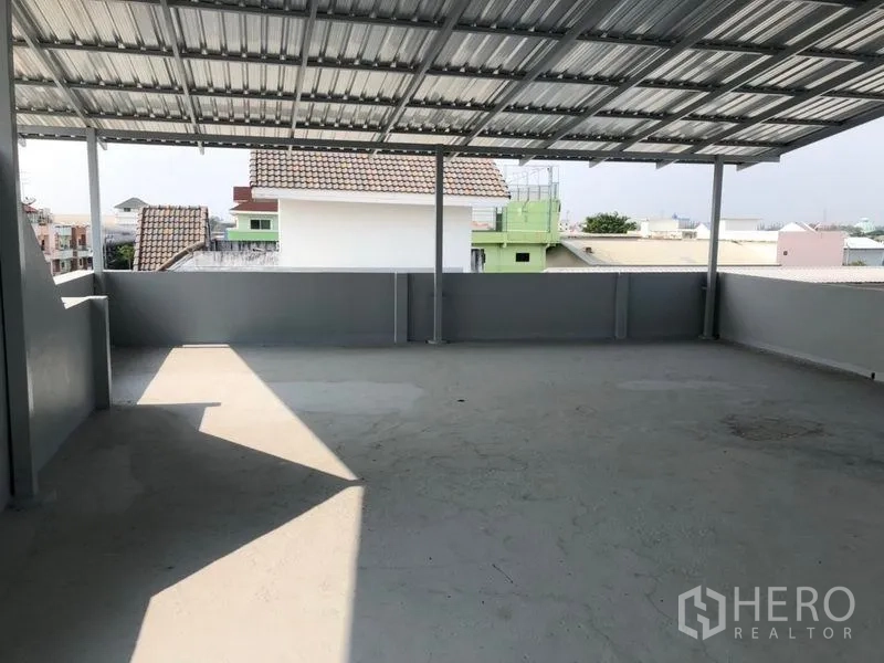 Factory for rent in Pak Kret, Nonthaburi - Rooftop terrace with metal canopy and neighborhood views, suitable for break area.
