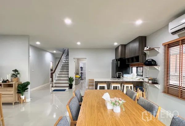 Detached House for rent or sale in Lam Luk Ka, Pathum Thani - Open-plan dining and kitchen with island, staircase and recessed lighting.