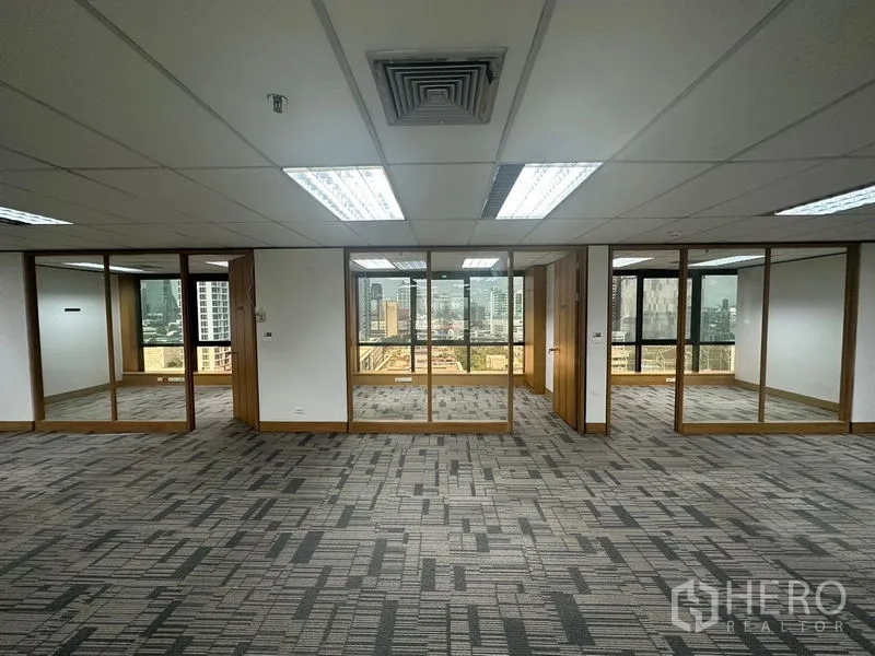 Office Space for rent in Khlong Toei, Bangkok - Row of glass-walled private offices facing city views within an open workspace.