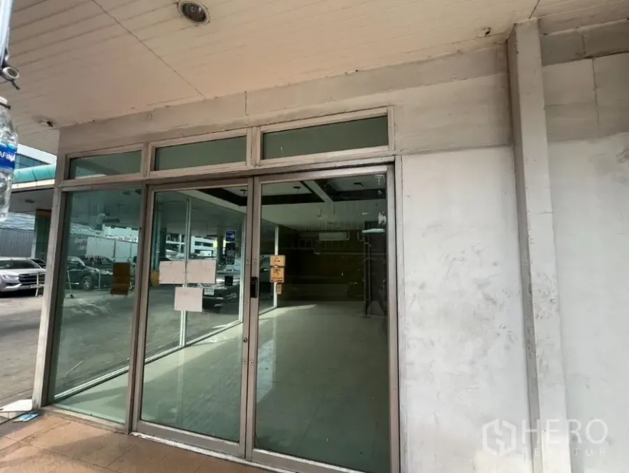 Retail Space for rent in Khlong Toei, Bangkok - Glass-front retail entrance with sliding doors and tiled floor facing a parking area.