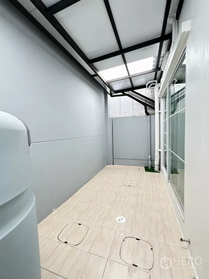 Townhouse for rent in Prawet, Bangkok - Covered utility terrace with tiled floor and sliding glass door.
