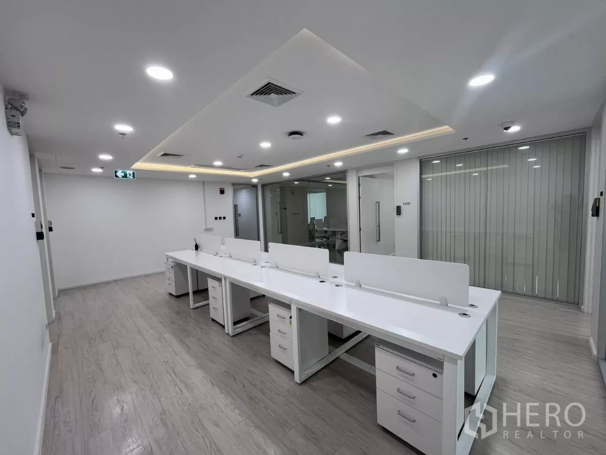 Office Space for rent in Din Daeng, Bangkok - Open-plan workspace with long bench desks, storage drawers and glass meeting room beside it.