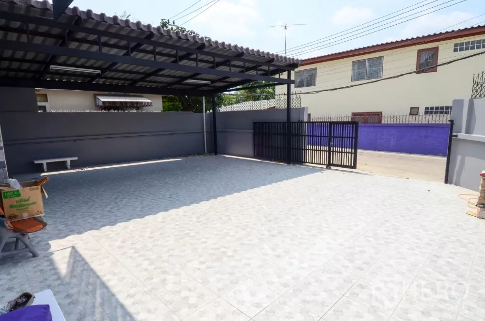 Home Office for rent in Lat Phrao, Bangkok - Wide tiled driveway and gate with roofed parking area for multiple cars.