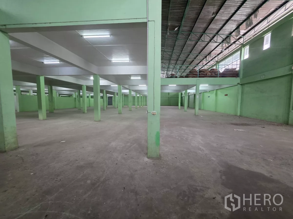 货栈 出租在Bang Khun Thian, Bangkok - 宽阔室内仓储区，荧光照明与金属屋顶，侧边设夹层