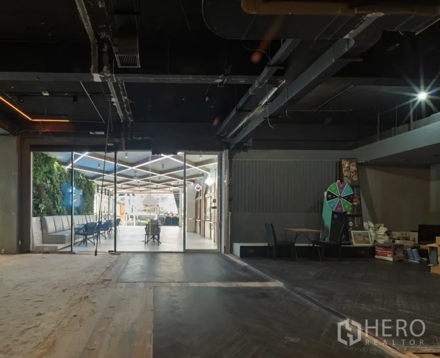 零售空间 出租在Watthana, Bangkok - 原始状态的零售室内，玻璃门面连通明亮中庭与立体绿植区。