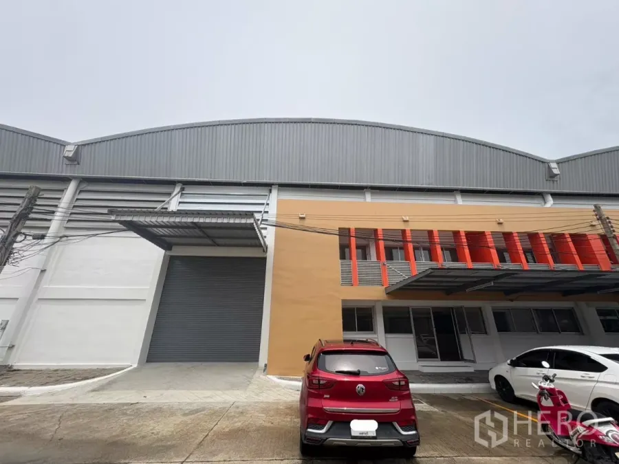 Factory for rent in Bang Phli, Samut Prakan - Modern factory-warehouse facade with loading ramp, roller shutter door and parking in Bang Phli.