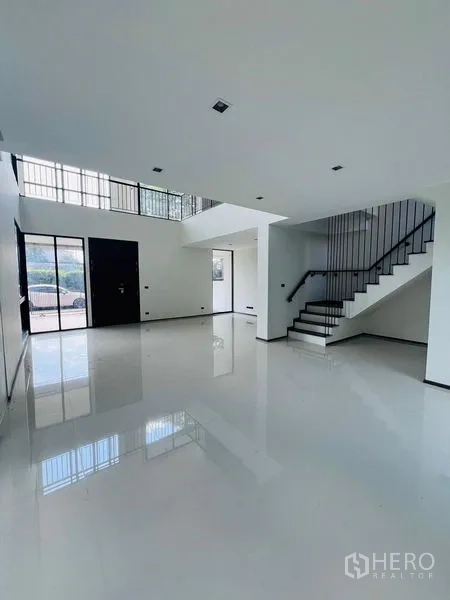 Home Office for sale in Bang Khen, Bangkok - Double-height lobby of a modern home office with glossy tile floors, black steel staircase and glass doors in Bang Khen, Bangkok.