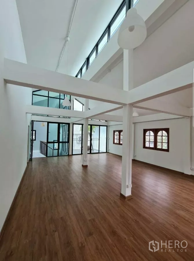 Home Office for rent in Lat Phrao, Bangkok - Upper level open space leading to glass landing and balcony, wood floors throughout.