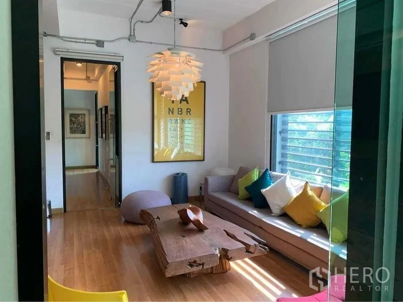 สำนักงานที่บ้าน ขายในWang Thonglang, Bangkok - ห้องนั่งเล่นอบอุ่น โซฟาพร้อมหมอนสีสัน โคมไฟแขวน และโต๊ะกลางไม้ชิ้นเดียว