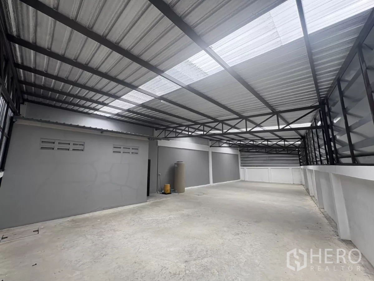 Factory for rent in Phra Samut Chedi, Samut Prakan - Long covered loading or storage zone with translucent roof panels for natural light.