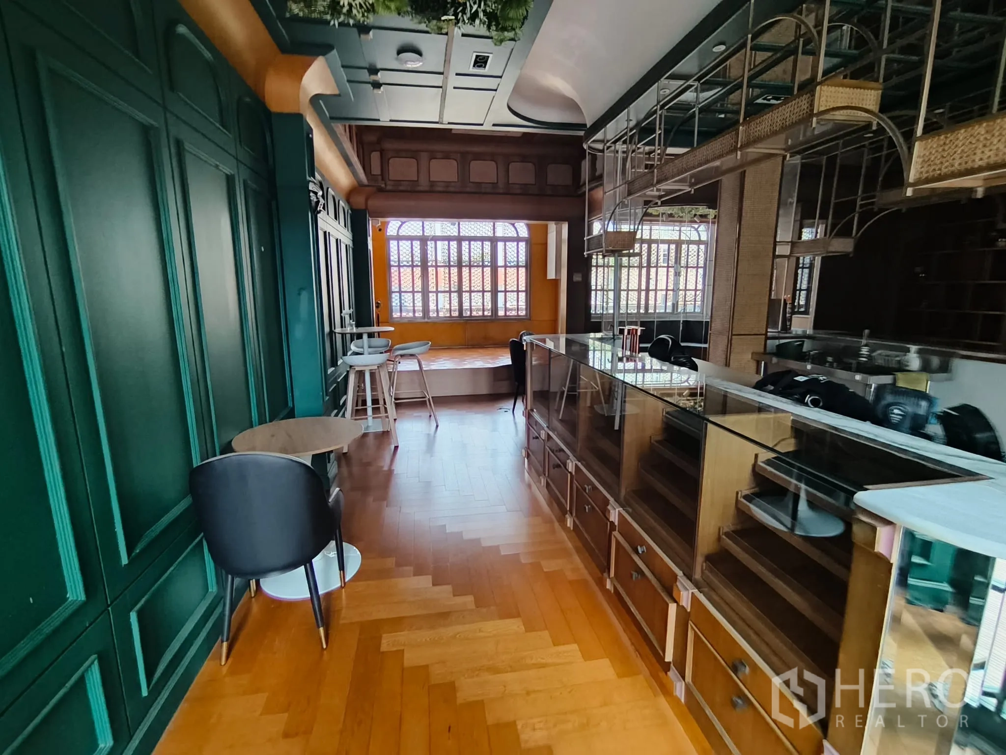 Shophouse for rent in Watthana, Bangkok - Stylish bar-style interior with green paneled walls, display counters and herringbone floor.