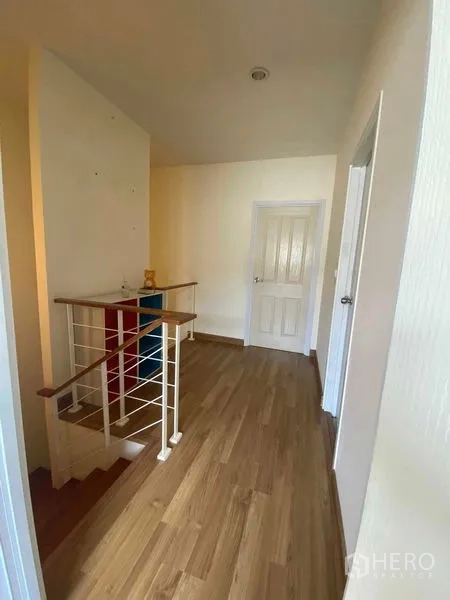 Townhouse for rent in Suan Luang, Bangkok - Landing and staircase with wooden handrail connecting upper bedrooms.
