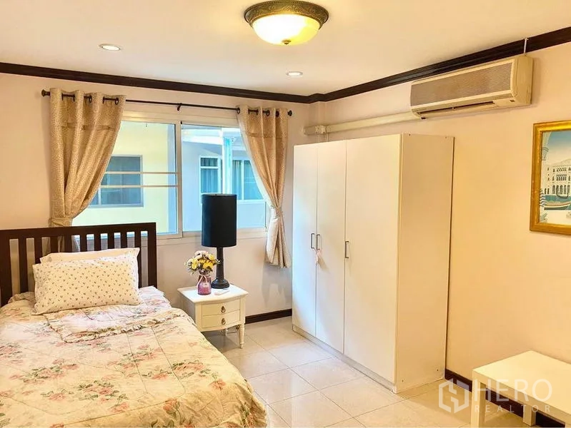 联排别墅 出租或出售在Prawet, Bangkok - 带空调的卧室，单人床、白色衣柜和两扇窗。