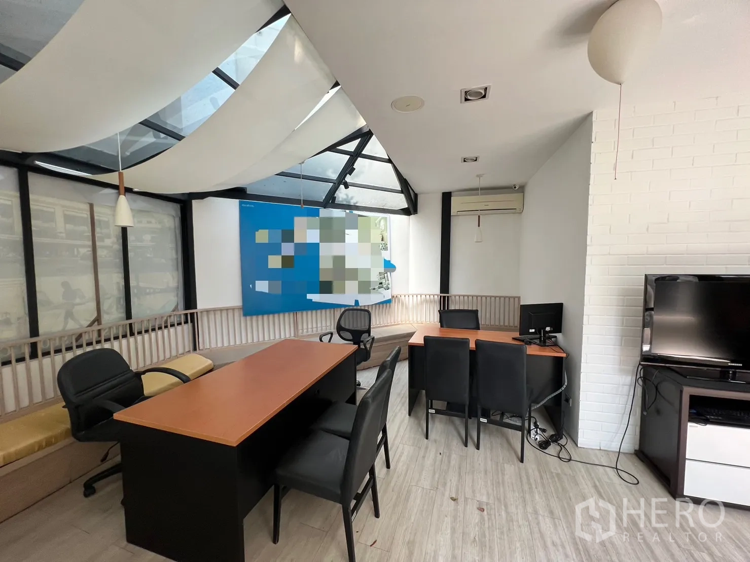 Retail Space for rent in Pathum Wan, Bangkok - Meeting and sales area with desks, black chairs, white brick wall and skylight ceiling panels.
