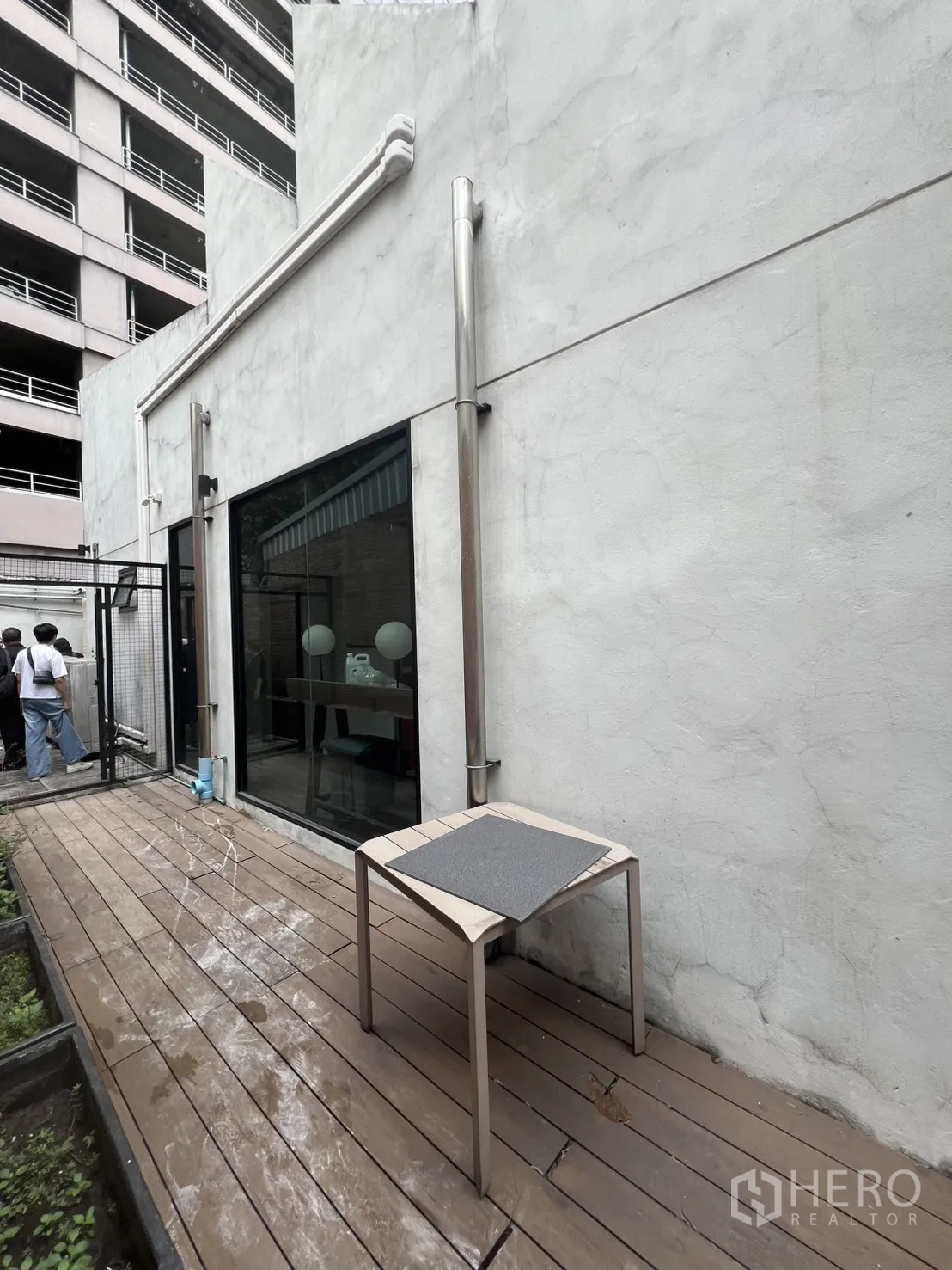 店屋 出租在Bang Rak, Bangkok - 建筑侧边木平台，白色外墙与玻璃门