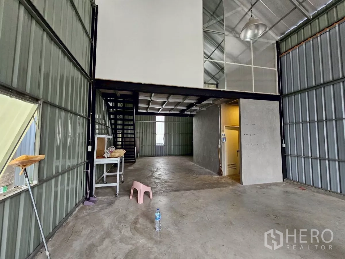 Warehouse for rent in Chatuchak, Bangkok - Open-plan warehouse interior with mezzanine, staircase and concrete flooring.
