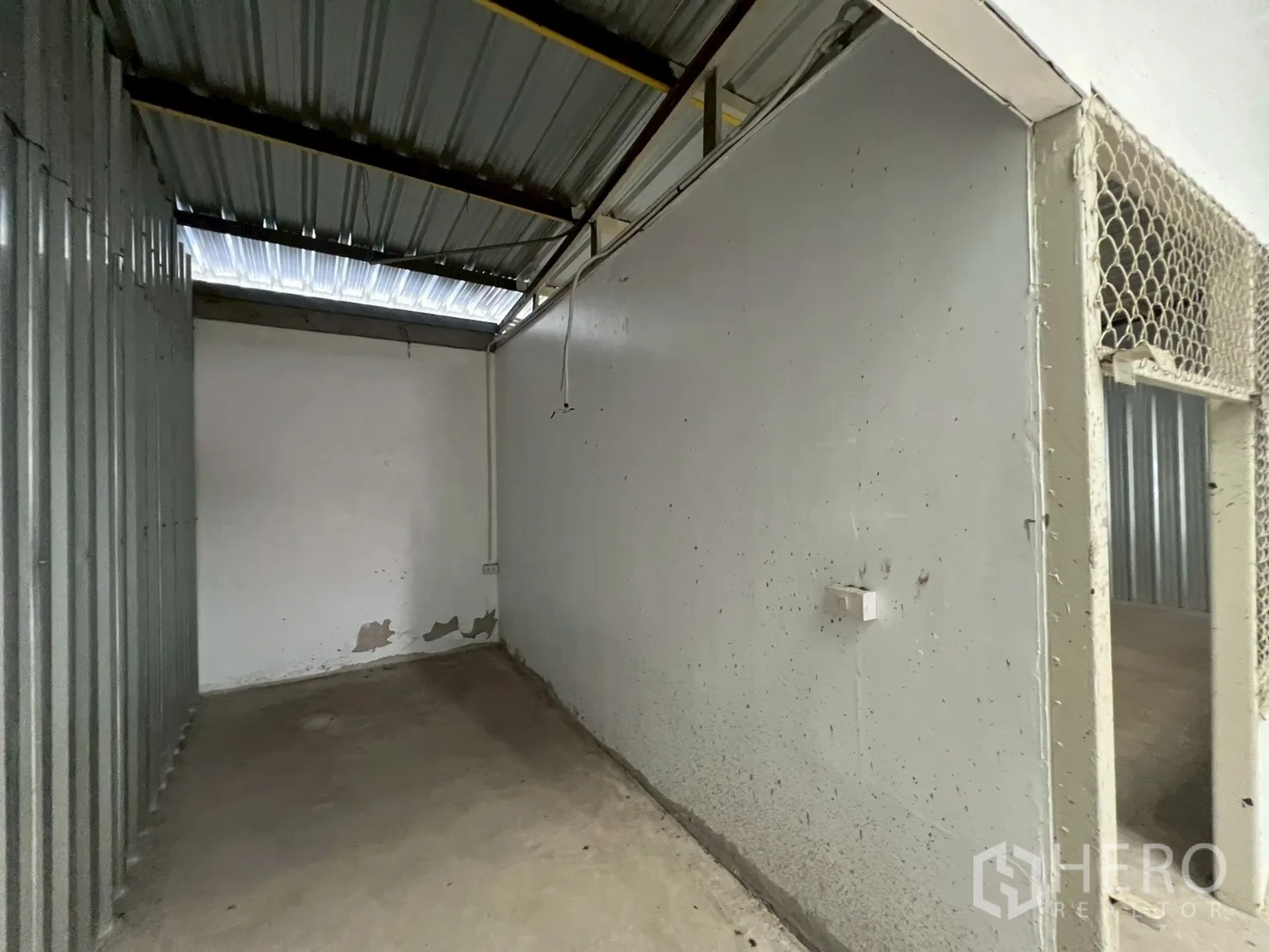 Warehouse for rent in Min Buri, Bangkok - Another angle of a small storage room with corrugated metal wall and concrete floor.