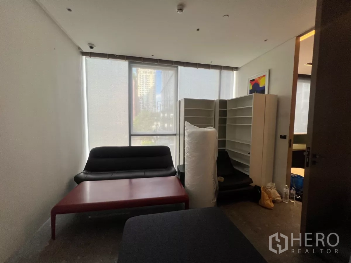 Retail Space for rent - Compact room with roller blinds, sofas and storage shelves, suitable for treatment or consultation area.