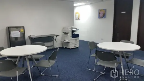Office Space for rent in Ratchathewi, Bangkok - Shared pantry and break area with round tables, gray chairs, refrigerator and office copier.