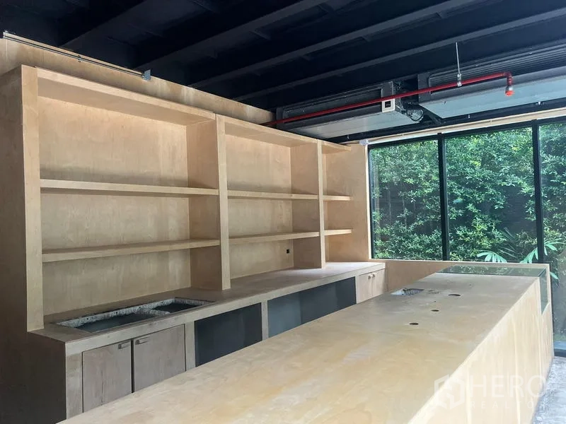 Retail Space for rent in Watthana, Bangkok - Close-up of wooden bar and shelving under exposed ceiling beside large windows.