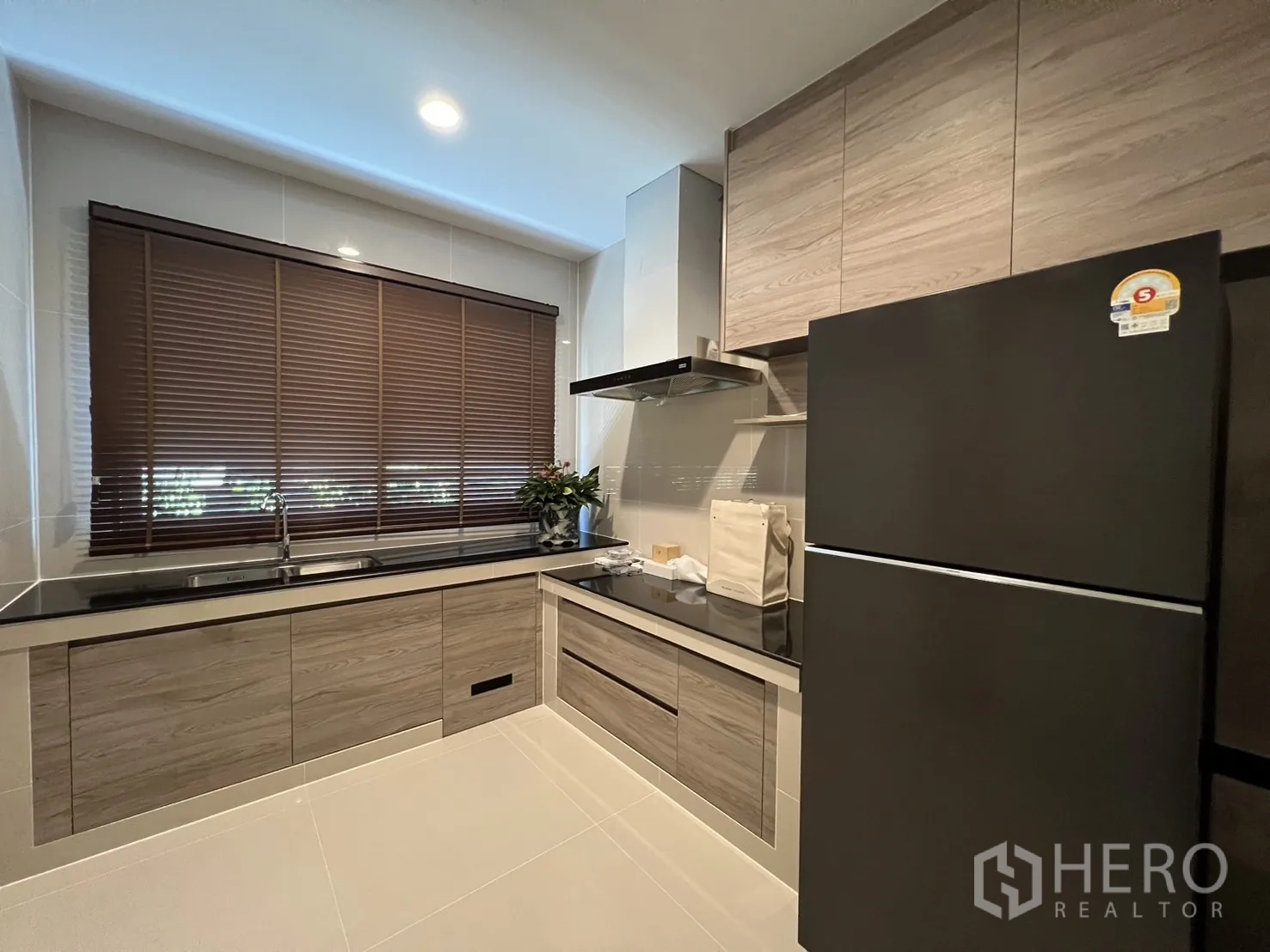 Detached House for rent or sale in Bang Kapi, Bangkok - Fully fitted Thai kitchen with wood cabinets, black counters and large fridge.