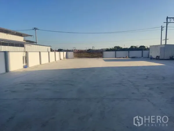 Factory for sale in Mueang Samut Sakhon, Samut Sakhon - Large gated concrete yard within walled compound, ideal for truck parking and loading.