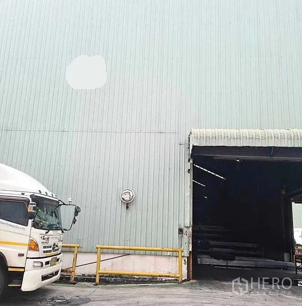 Warehouse for rent in Phra Pradaeng, Samut Prakan - Dock-height warehouse entrance with safety railings and truck access