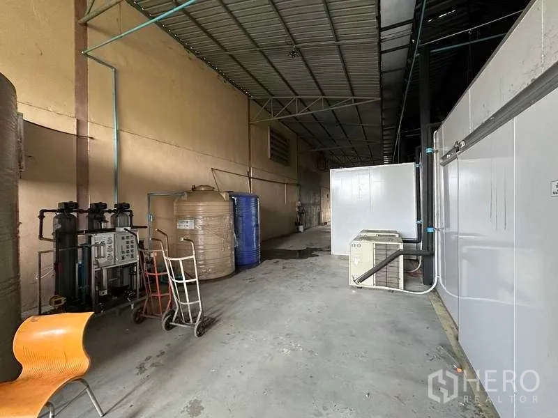 Warehouse for rent in Khlong Luang, Pathum Thani - Industrial side bay featuring water filtration tanks, piping and utility equipment.