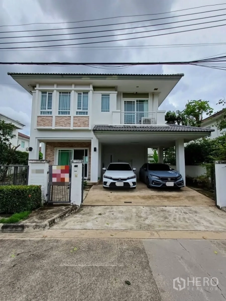 Detached House for sale in Bang Kapi, Bangkok - Front facade of a two-storey modern house with wide driveway and two-car carport.