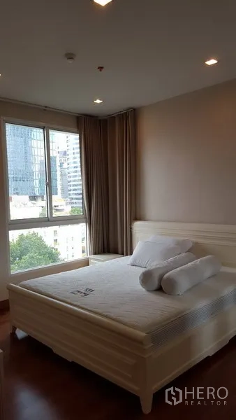 Condominium for rent in Bang Rak, Bangkok - Bright master bedroom with large window, city view and queen bed in Bang Rak condo.