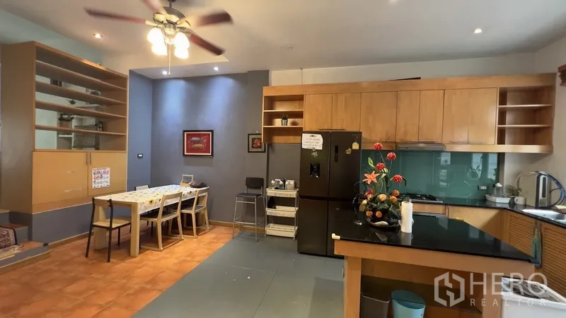 Townhouse for rent or sale in Khlong Toei, Bangkok - Kitchen and dining area with ample cabinetry and breakfast table.