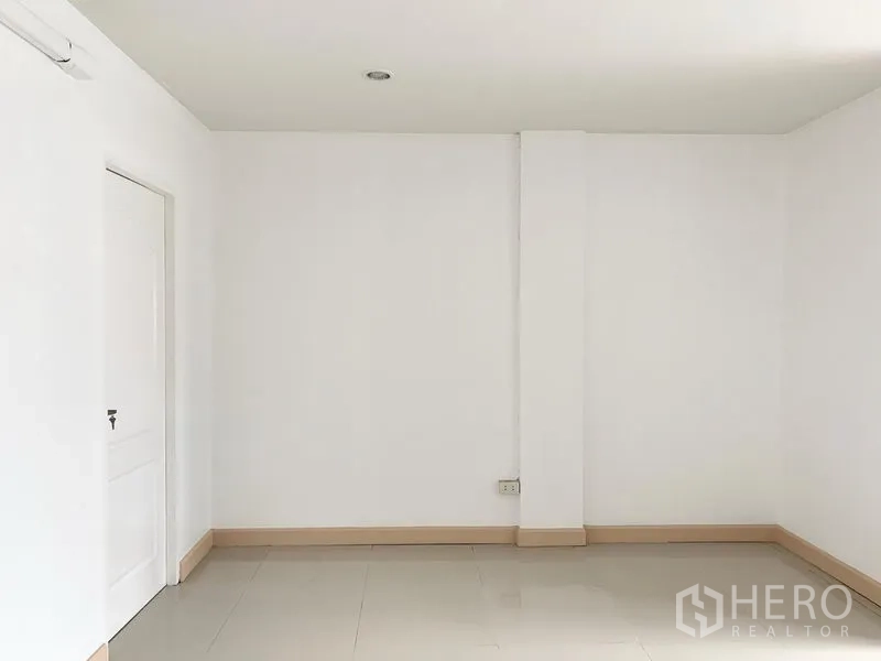 Townhouse for rent in Khlong Toei, Bangkok - Clean white room with glossy tile flooring and an air-conditioning point.