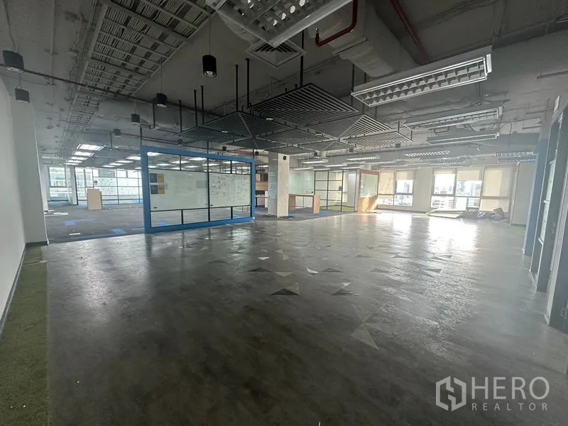 Office Space for rent in Bang Rak, Bangkok - Large workspace featuring a blue-framed glass room and abundant natural light.