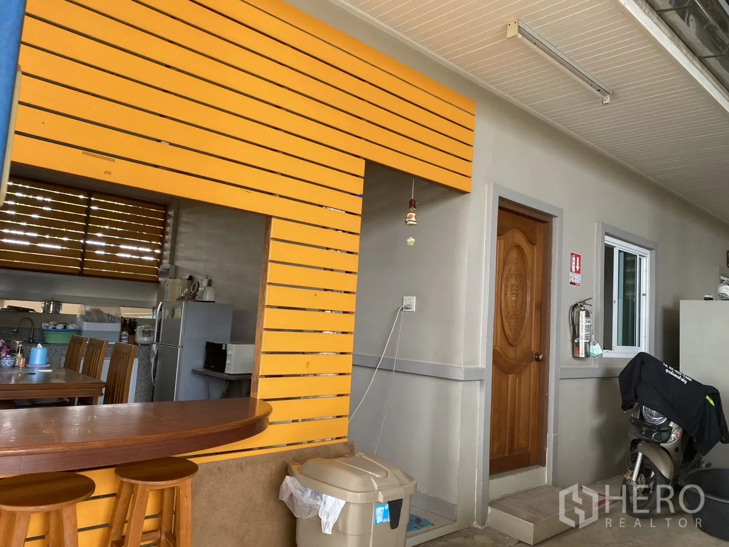 Factory for sale in Khlong Luang, Pathum Thani - Staff pantry with a wooden counter, stools, and a view into the kitchen.