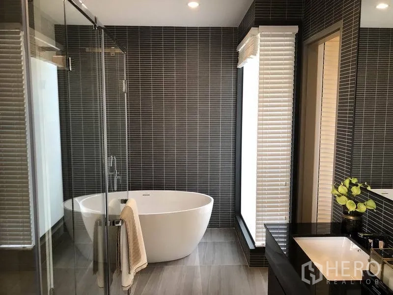 Detached House for sale in Bang Kapi, Bangkok - Luxury bathroom featuring a freestanding soaking tub, glass shower and dark tile accent wall.