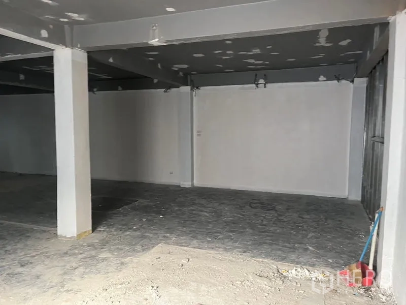 Retail Space for rent in Pathum Wan, Bangkok - Empty bay with white walls, gray ceiling and a metal panel to the right.