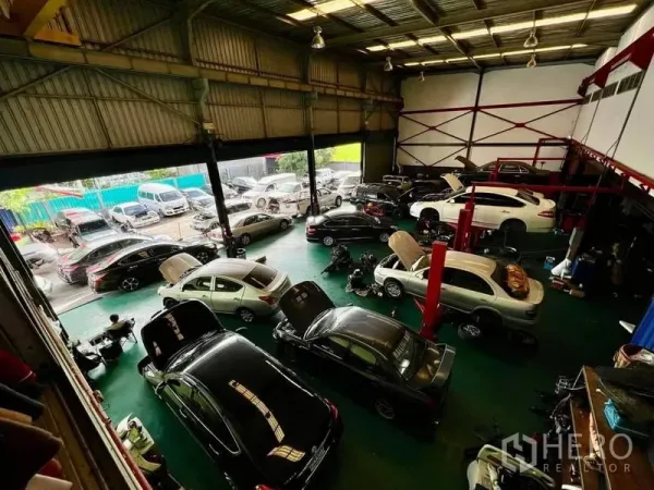Warehouse for rent in Thanyaburi, Pathum Thani - High-clearance warehouse workshop with multiple service bays, car lifts and a wide open frontage for vehicles.