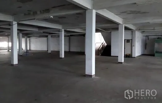 Factory for sale in Bang Phli, Samut Prakan - Open production floor with concrete columns and stair access.