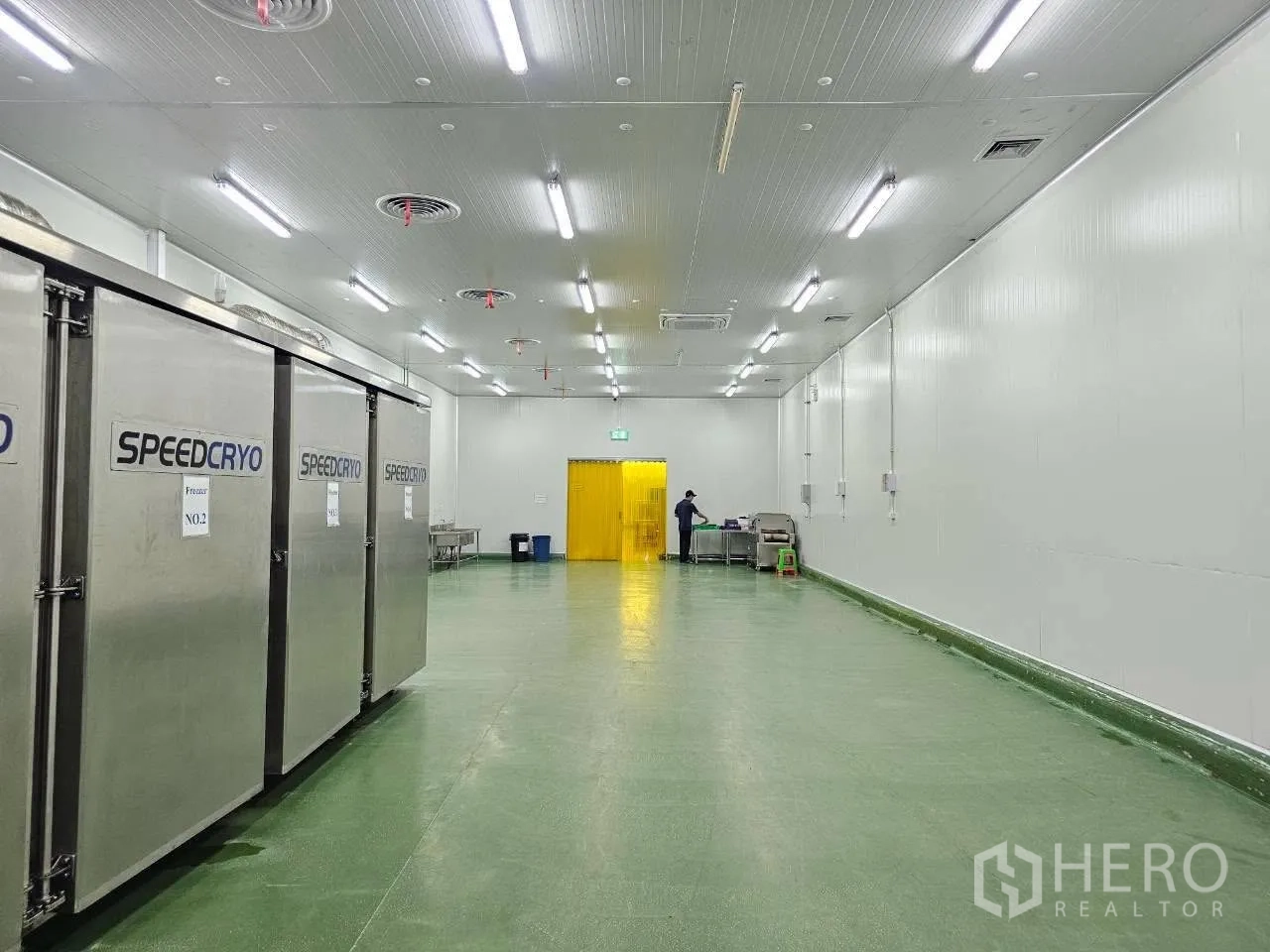 Factory for rent in Mueang Samut Sakhon, Samut Sakhon - Room housing industrial freezers beside open work area.