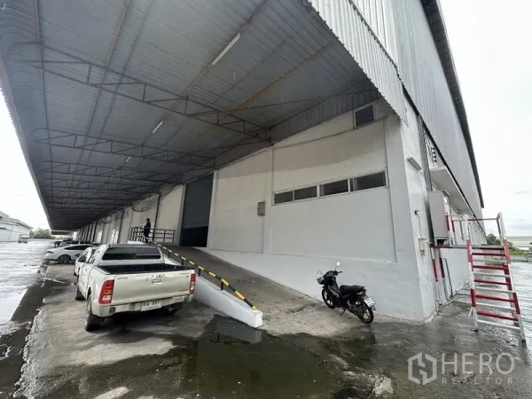 货栈 出租在Phra Nakhon Si Ayutthaya - 侧视图，卡车坡道通向钢结构屋顶下的升高月台。