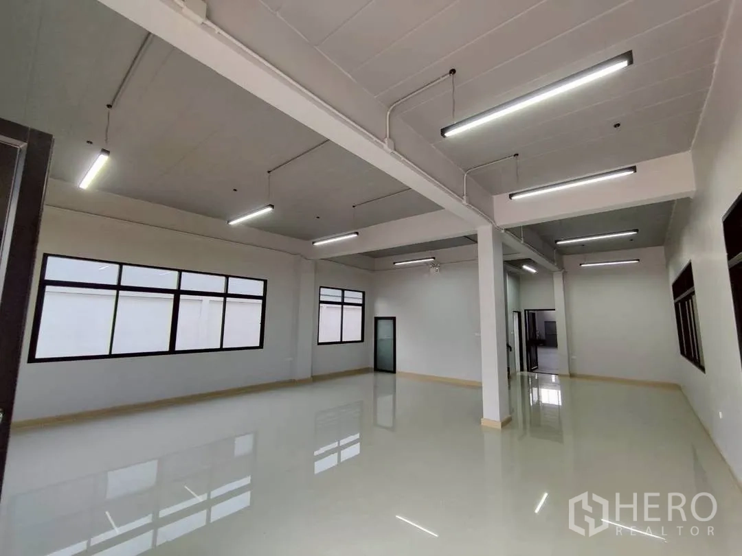 Factory for rent in Krathum Baen, Samut Sakhon - Bright office room with glossy tiled floor, strip lighting, and black-framed windows.