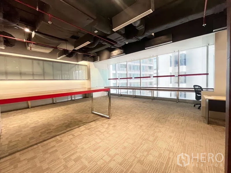 Office Space for rent in Watthana, Bangkok - Large office area with floor-to-ceiling windows, long counter along the glass and city building views.