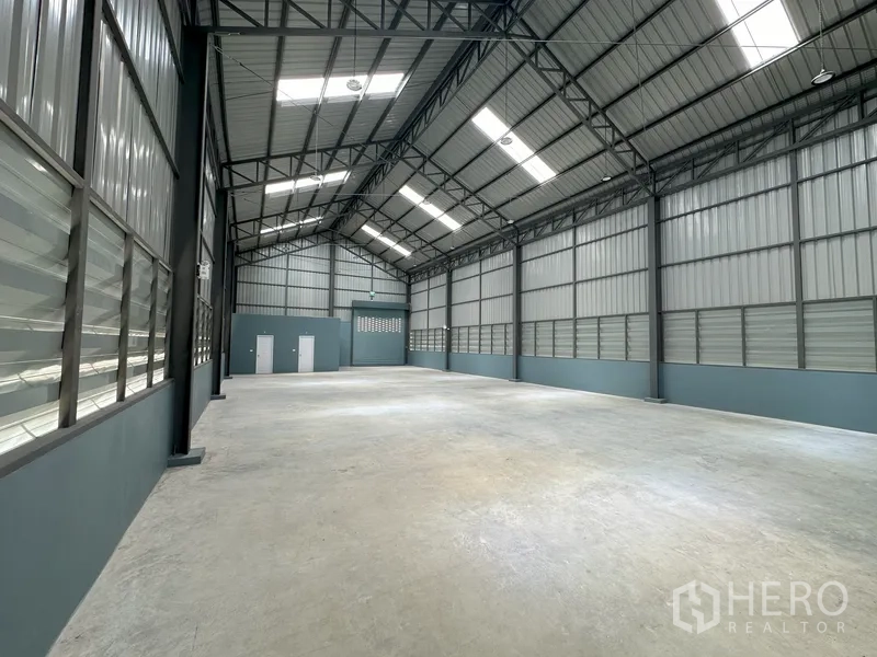 工厂 出租在Khlong Luang, Pathum Thani - 高挑钢桁架屋顶的仓厂大厅，带天窗与光滑混凝土地面。