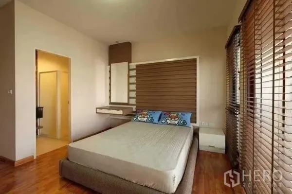 Townhouse for rent in Phra Khanong, Bangkok - Bright bedroom with wood floors, feature headboard and ensuite bathroom entrance.