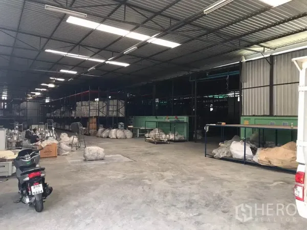Warehouse for rent in Mueang Chon Buri, Chon Buri - Warehouse loading and staging zone with worktables, storage racks and open bay access.