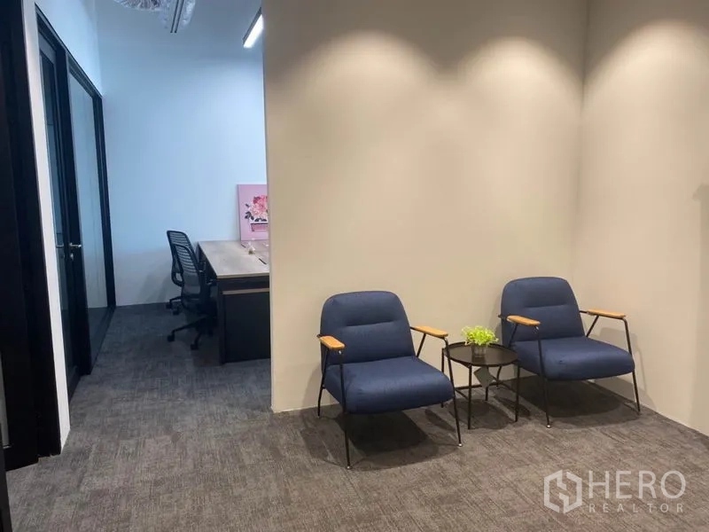 Office Space for rent in Pathum Wan, Bangkok - Cozy waiting nook with two blue lounge chairs and side tables beside the corridor.